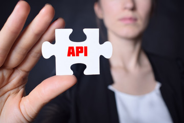 Businessman holding a puzzle with the inscription:API