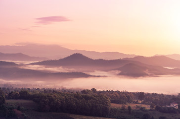 landscape view of sunrise on high angle view with white fog in early morning over rainforest mountain