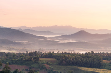 landscape view of sunrise on high angle view with white fog in early morning over rainforest mountain in thailand 