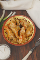 Stuffed Rolled Cabbage meat in Leaves in a Ceramic Plate with White Napkin,Parsley on a Rustic Wooden background. Traditional Romanian Russian Ukrainean Food.