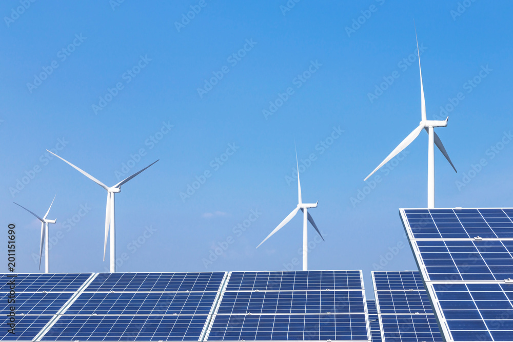 Wall mural rows array of polycrystalline silicon solar panels and wind turbines generating electricity in hybri