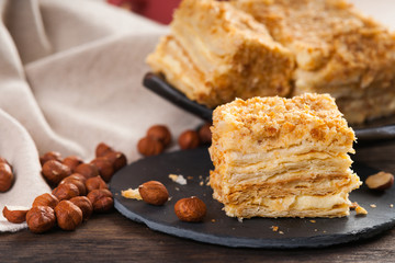 Slice of sweet classic layered cake Napoleon and hazelnuts 