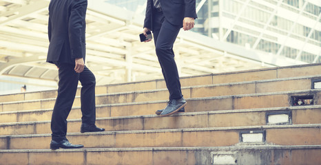 Two Businessmen walking up the stairs in a rush hour to work. Hurry time.vintage color,business concept