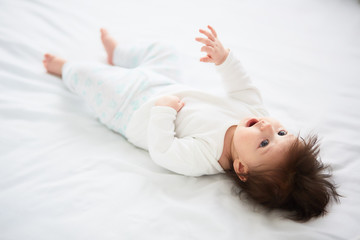 The small baby lies on the bed