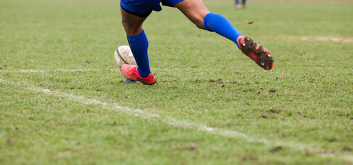 rugby player preparing to kick the oval ball during game
