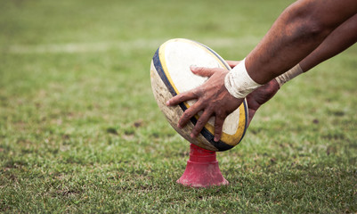 Fototapeta rugby player preparing to kick the oval ball during game obraz