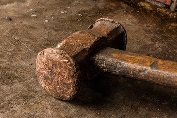 Fototapeta premium Old rusty hammer on old metal table background. Closeup view of vintage blacksmith hammer.