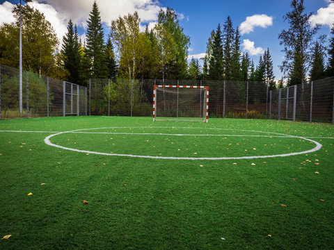 Soccer field with green grass yard and football goal in school area. beautiful sport playground.
