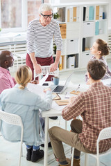 Obraz premium Senior businessman giving recommendation to his team at a meeting