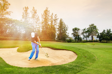 Man hitting golf ball on a golf course while on summer vacation.