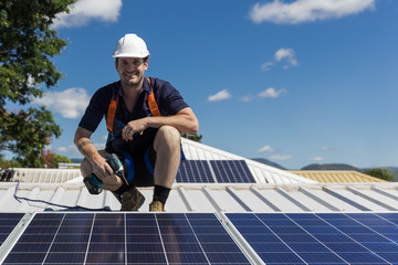Solar panel technician with drill installing solar panels