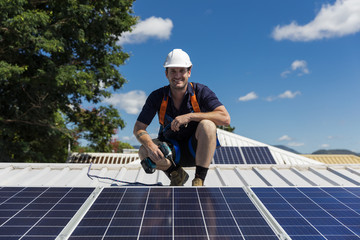 Solar panel technician with drill installing solar panels