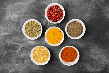 Various spices in bowls on black background. Top view. Food background