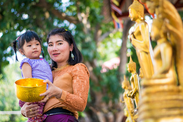 Water festival. Asia woman wearing Thai tradional costume Buddha Bathing in Songkran day water...