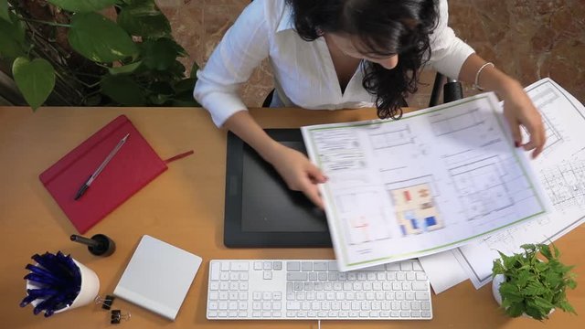 Female interior designer planning apartment layout with graphic tablet and pc. Woman drawing floor plan using digital devices. Caucasian architect drawing building plan. Architecture and technology
