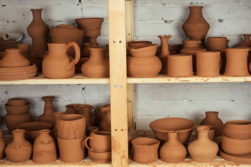 Fototapeta na wymiar A shelf with vases and pots of clay. potter, clay, vase, pottery and potter. shelves with brown pottery