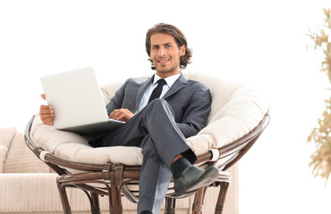 modern businessman with a laptop sitting in a stylish comfortable chair