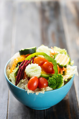 Vegetables salad in a bowl on wooden background, healthy food