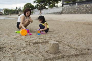 Mother and daughter building sand castle