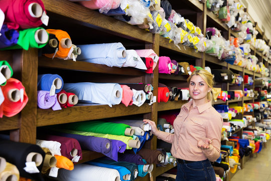 salesgirl demonstrating wide range of stylish cloth