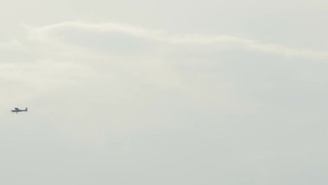 Propeller little plane is crossing the sky at distance.