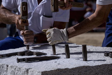 Close-up of the hands of a stonemason, hitting the stone
