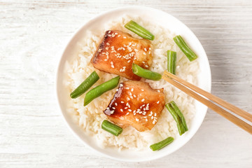 Fish fillet served with rice and green beans on wooden background