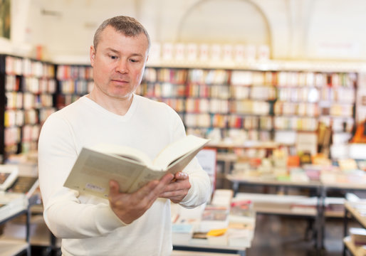 Man browsing inside of books while visiting library