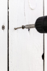 Eine Spanplattenschraube wird in ein Brett geschraubt