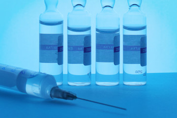 Syringe and ampoules on a blue background