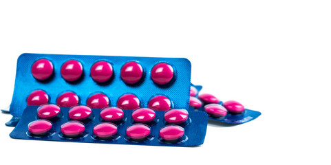 Ibuprofen in pink tablet pills pack in blue blister pack isolated on white background with copy space. Ibuprofen for relief pain, headache, high fever and anti-inflammatory. Painkiller tablets pills.