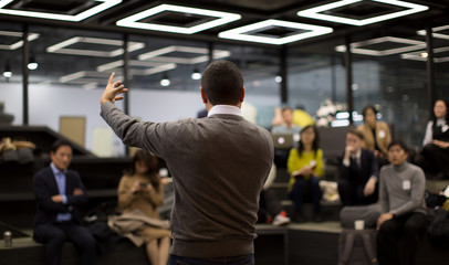 A Charismatic Presenter is Speaking to a Group of People