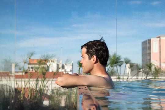 Young man on rooftop swimming pool