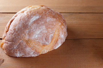 Sliced bread on a wooden background, two halves of wheat bread from a plate on pine boards, French dough for a designer, copy space, rustic style, wooden background, art