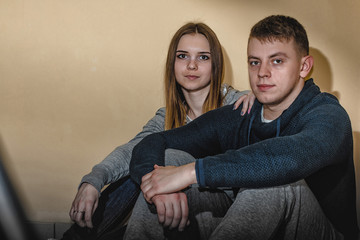 Teenagers boyfriend and girlfriend hugging each other in the corridor of an apartment building