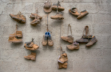 Old dirty shoes hanging on the wall