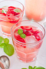 Fresh cool summer drink with strawberries and green basil, selective focus