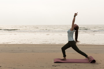 Fototapeta na wymiar Junge sportliche Frau am Strand mit verschiedenen Posen, Yoga, Konzept