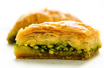 Baklava with pistachios, walnuts and honey on white background. Jewish, turkish, arabic traditional national dessert. Macro. Selective focus. Copy space