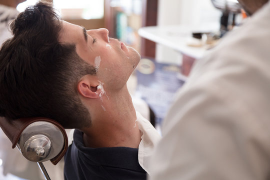 Man getting beard shaved in barber shop