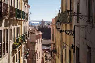 Typical rustic street in Lisbon overlooking the 25 de Abril Bridge