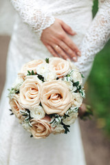 Beauty wedding bouquet in bride's hands, close - up