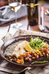 Roasted fish fillet with pumpkim pieces and herb decoration in pub or restaurant