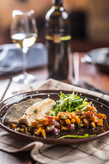Roasted fish fillet with pumpkim pieces and herb decoration in pub or restaurant