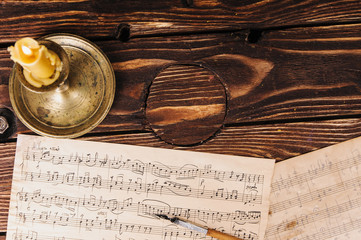 Sheet with notes, a candle and a pen on the table. Table composer of the 19th or 20th century.