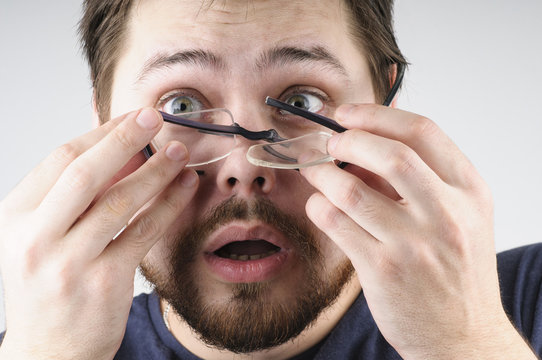 Shocked man with broken glasses on his face