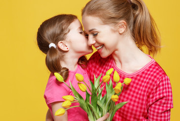 Fototapeta na wymiar concept of mother's day. mom and child with flower on colored background