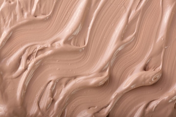 Beige liquid foundation makeup as a background. Top view. Flat lay pattern