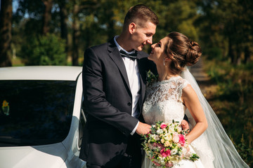 Beautiful newlyweds walking in the park admiring each other and kissing