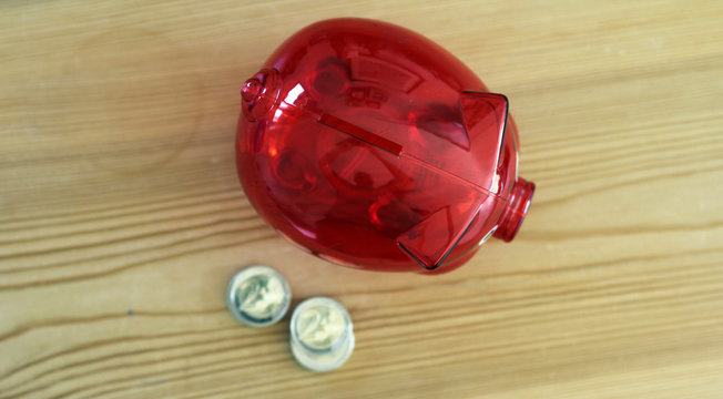 Rotes Sparschwein und M&uuml;nzen